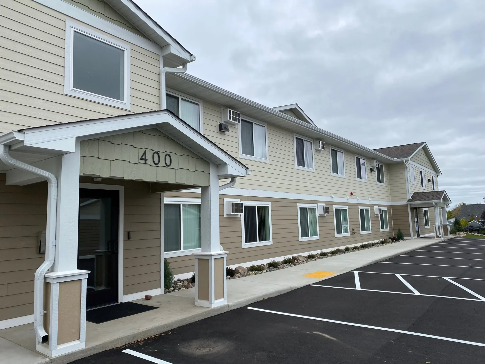 Two-story beige building with parking lot